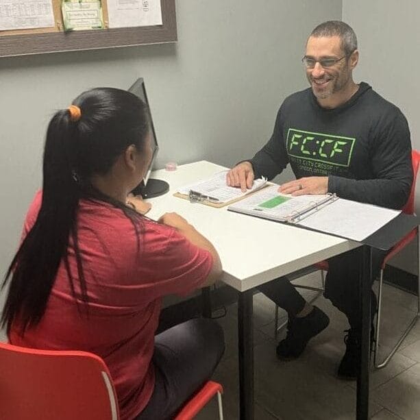 CrossFit coach seated with nutrition coaching client in London Ontario